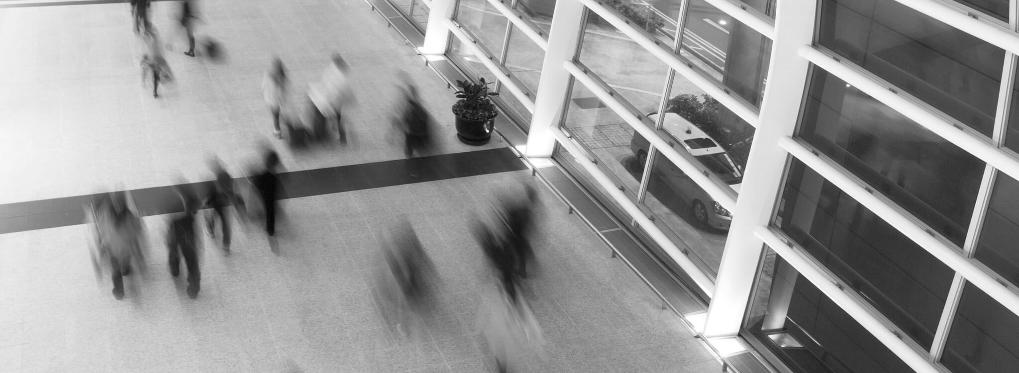 A black and white photo of people walking in an airport